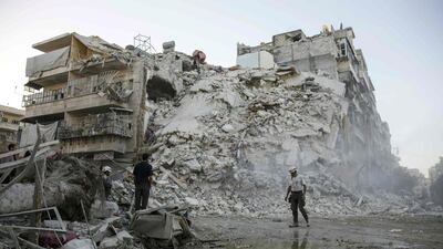 Members of the Syrian Civil Defence, known as the White Helmets, search for victims in the rubble of a destroyed building following reported air strikes on the rebel-held Qatarji neighbourhood of Aleppo on October 17, 2016. Karam Al Masri/AFP