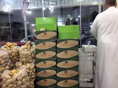 Hajji Hassem stands next to boxes of Saudi and Iraqi dates in his shop in Fallujah. Sofia Barbarani / The National