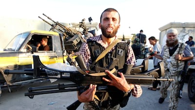 A Libyan rebel holds weapons at Bab Al-Aziziya compound in Tripoli August 23, 2011. Joyful Libyan rebels overran Muammar Gaddafi's Tripoli bastion on Tuesday, seizing weapons and loot and destroying symbols of a 42-year dictatorship they declared was now ???