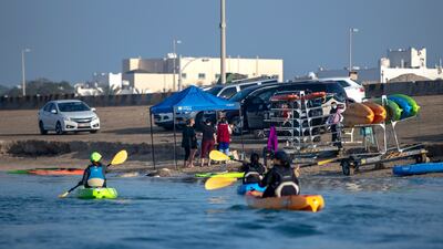 Parents head out in kayaks while their children take part in their sailing lesson.