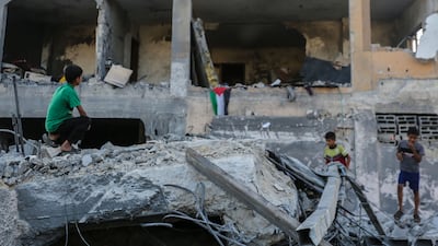 People in Khan Younis search through buildings that were destroyed during Israeli air raids in the southern Gaza Strip on Sunday. Getty Images