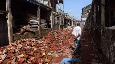 The top two storeys have already been torn down and workmen with sledgehammers are hacking at what is left, but at Mumbai’s Botawala Chawl apartment complex four families refuse to leave. Indranil Mukherjee / AFP