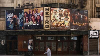 A man walks past the historic Metro cinema theatre on Talaat Harb street in the deserted city centre of Cairo, on the first day of Eid Al Fitr. AFP