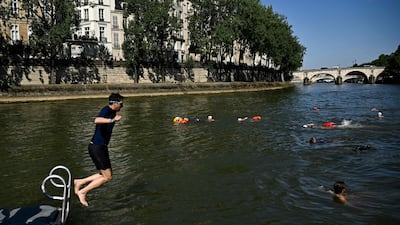 A resident dives in the Seine after the mayor of Paris swam in the river to demonstrate that it is clean enough to host outdoor swimming events at the Olympics. AFP