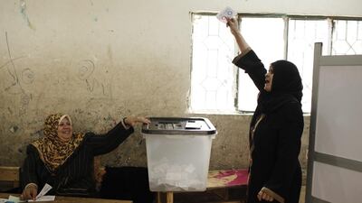 A woman places holds up her ballot before voting on Tuesday in Egypt's referendum on a new constitution. Ed Giles/Getty Images