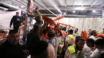Medics and rescue workers carry stretchers after dozens of people were killed or injured during the Jewish festival in Mount Meron, northern Israel. Reuters