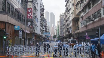 Police officers stand guard behind a barrier in an area under lockdown in the Jordan area of Hong Kong, China. Bloomberg