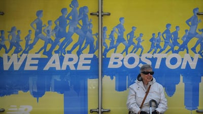 A woman waits at a bus stop near the finish line of the Boston Marathon in Boston, Massachusetts on April 17, 2014. The 118th running of the Boston Marathon will be held April 21. REUTERS/Brian Snyder
