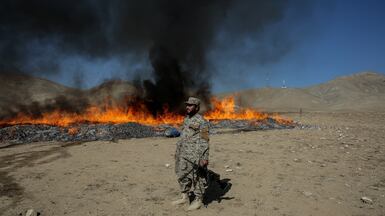 Security officials guard the area as seized illegal drugs are burnt in Kabul, Afghanistan. EPA