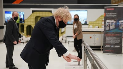 Boris Johnson sanitizes his hands at the BAE Systems facility. The prime minister's visit comes to mark the publication of the UK government's Integrated Review. Reuters