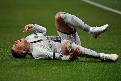 Paris Saint-Germain's French forward Kylian Mbappe lies on the ground after getting injured. AFP