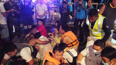 Rescued tourists gather on a pier. AP Photo
