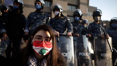 A Lebanese protester sits in front of riot police in the capital Beirut. AFP