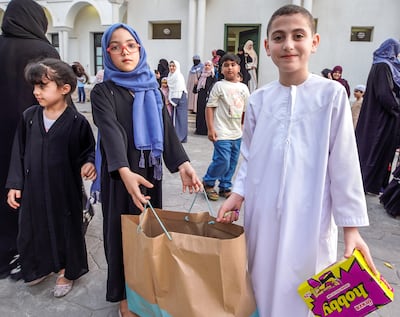 Children distribute candies after morning Eid Al Adha prayers at the Zayed the Second Mosque in Abu Dhabi's Khalidiya district. Victor Besa / The National
