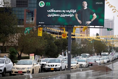 Traffic rolls past an electoral campaign poster of Bafel Talabani. AFP