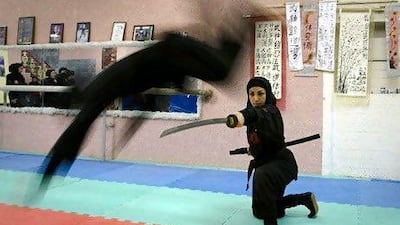 A Ninjutsu practitioner jumps over a sword as members of various Ninjutsu schools showcase their skills to the media in their gym 45 kilometres from Tehran in February.