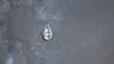 The aluminum and green composite material left behind following the removal of an unexploded limpet mine.