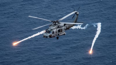 A US Navy MH-60R Sea Hawk helicopter from the "Blue Hawks" fires chaff flares during a training exercise near the aircraft carrier USS Carl Vinson. Reuters