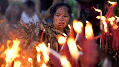 A devotee lights candles outside the church of St John the Baptist