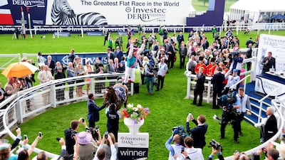 The large sign proclaiming the Epsom Derby as "The Greatest Flat Race in the World" looms large next to the racetrack. Pat Healy / racingfotos.com