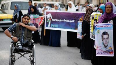 Moamen Qreiqea adjusts his camera strap while covering protesters calling for the release of Palestinian prisoners from Israeli jails.