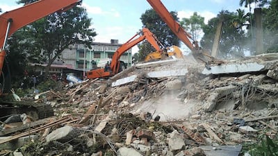 Indonesian search and rescue personnel work to rescue people trapped under the rubble of a collapsed building following the earthquake in Pidie, Aceh province. Chaideer Mahyuddin / AFP