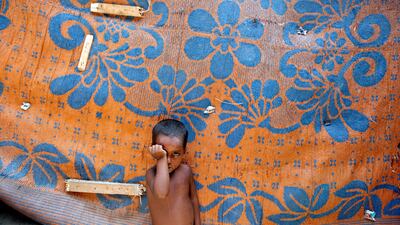 A boy from the Rohingya community stands outside a shack in a camp in Delhi. A challenge to the Indian government's order to deport all Rohingya will be heard by the supreme court on September 4, 2017. Cathal McNaughton / Reuters / August 17, 2017