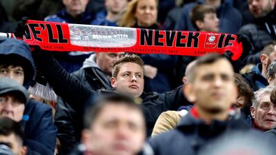 A Manchester United fan with a scarf that reads 'We’ll never die' in honour of the Busby Babes. EPA