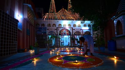 On the eve of the Diwali festival, a Hindu man lights small lamps outside of the Kali Mata temple in Umerkot, Tharparkar. Mobeen Ansari