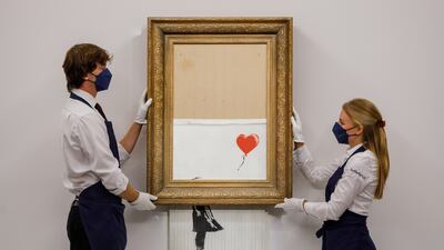 Banksy's 'Love is in the Bin' (2018) started going through a shredder during a Sotheby's auction in London in 2018. Getty Images
