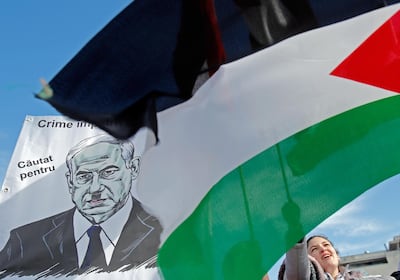 A woman waves the Palestinian flag next to the portrait of Israeli Prime Minister Benjamin Netanyahu during a protest against the so-called 'deal of the century'. EPA