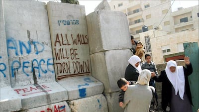 Palestinians avoiding the 8 meter high wall that divides Abu Dis and climb s over a smaller barricade up the road to pass to the West Bank side. SIPA