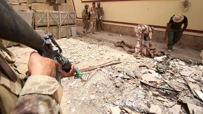 Members of Iraqi pro-government forces check an unidentified body.
