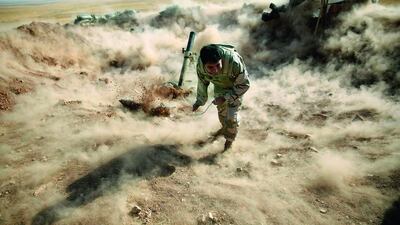 A Kurdish peshmerga fighter launching mortar shells towards Zummar, controlled by ISIL, near Mosul on September 15. Ahmed Jadallah / Reuters
