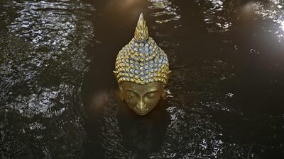 TOPSHOT - Floodwaters cover a Buddhastatue of at Wat Taku Buddhist temple in Bang Ban district in the central Thai province of Ayutthaya on November 14, 2025. (Photo by Lillian SUWANRUMPHA / AFP)