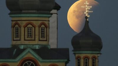 The super moon during a lunar eclipse in the sky above a church in Turets village, some 110km from Minsk, Belarus. Tatyana Zenkovich / EPA