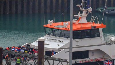 Migrants leave a British Border Force boat in Dover, England, on Monday after they were picked up in the English Channel. EPA