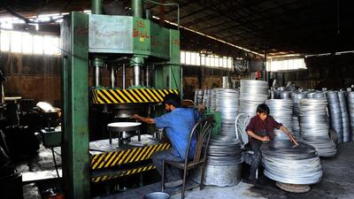 Afghan labourers work a press at an aluminium workshop in Herat.