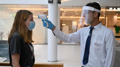 A security guard wearing a face mask checks the body temperature of a customer in a shopping mall in Dbayeh, northern Beirut, Lebanon. EPA