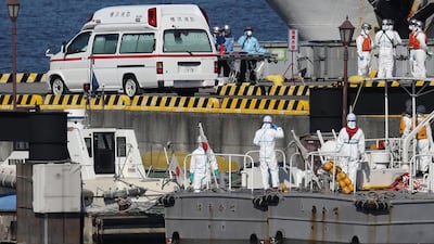 Workers in protective gear are seen next to a waiting ambulance at the Japan Coast Guard base in Yokohama. AFP