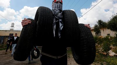 A protester carries tyres to burn during clashes in the occupied West Bank. AFP