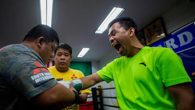 Manny Pacquiao gets his gloves put on before a training session at Wild Card Gym. AFP