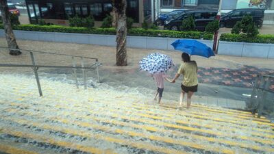 Hong Kong residents walk down flooded steps during heavy rain. Bloomberg