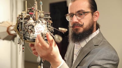 Mohamad Hafez with his suspended sculpture, ‘Hung Memories’, on show at Sharjah Art Museum. Pawan Singh / The National