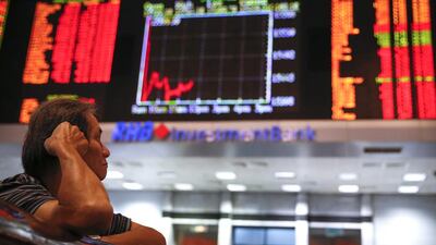 MALAYSIA - Investors watch the trading board at a private stock market gallery in Kuala Lumpur. The Malaysian stock index was down 17.19 points late Monday. Vincent Thian / AP Photo
