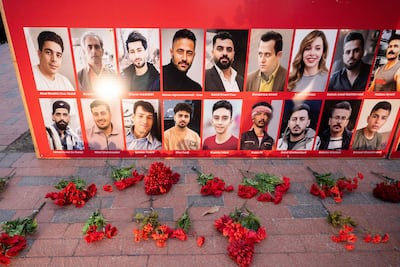 Flowers are placed next to a display with photos of Iraninan people killed during the recent protests in Iran, during a rally and vigil in their honor by Iranian Americans, outside the White House in Washington, DC, January 16, 2026. AFP