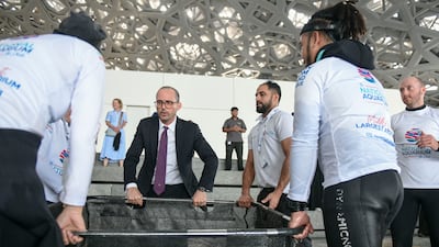 Manuel Rabate, director of Louvre Abu Dhabi, helping to release the turtles into the lagoon