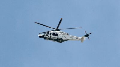 A Dubai Police helicopter circles the area.