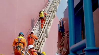 Technicians climb the ladder of the Nautica, a replacement oil tanker for the decaying FSO Safer. Reuters.