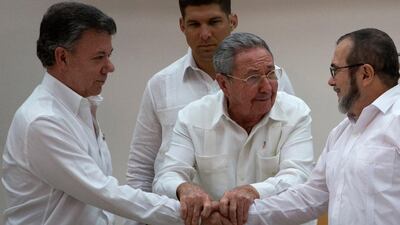 In 2015 Cuba's President Raul Castro brought together the hands of Colombian President Juan Manuel Santos and FARC Commander Timoleon Jimenez. Luciano Marin says he regrets the decision by the FARC to hand over its weapons. AP